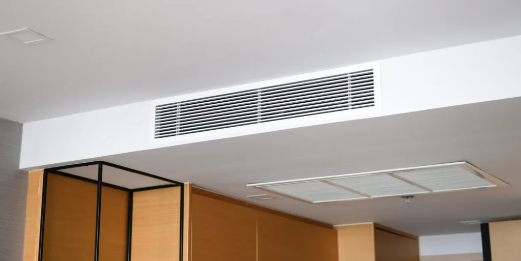A large rectangular air conditioning vent in a modern ceiling, with another vent visible in the foreground.