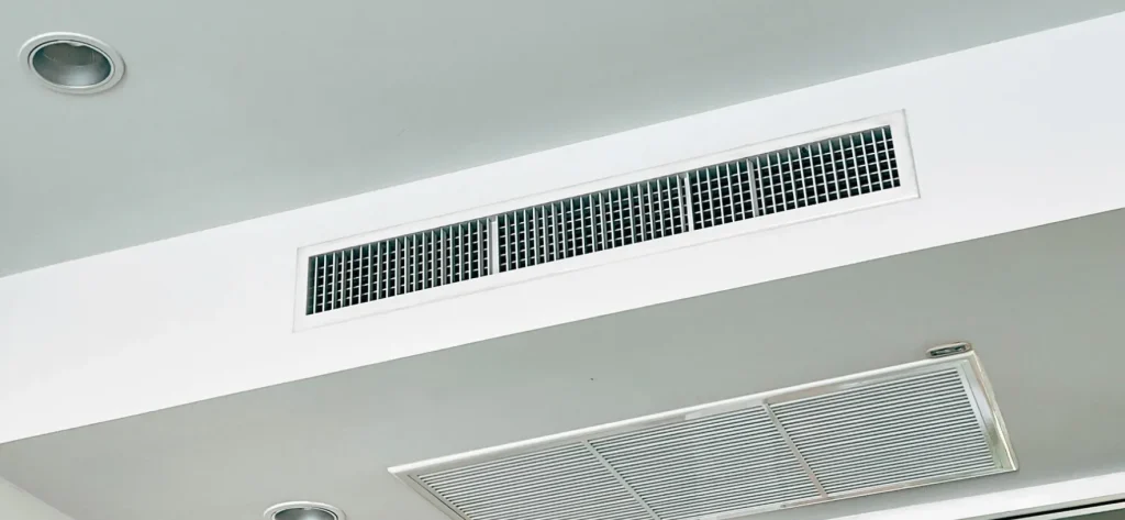 A photo of linear bar grille air conditioning unit part, installed in a white ceiling