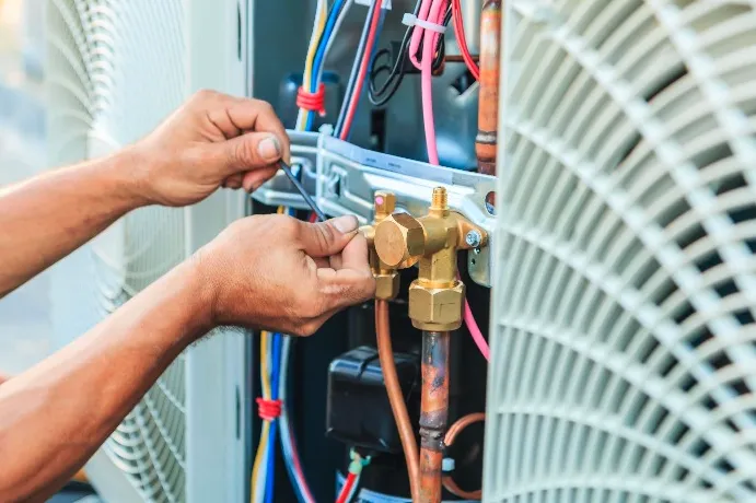 Technician working on an AC compressor, the most important part of an air conditioning unit