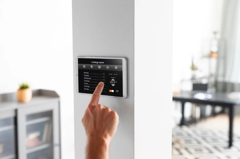 Close-up of hand on wall-mounted smart AC controller