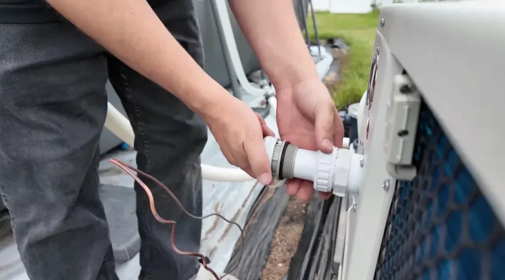 Connecting hose to water outlet on outdoor pump unit