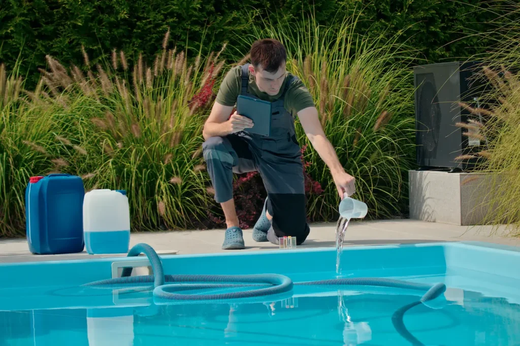 Man testing and adding chemicals to swimming pool water