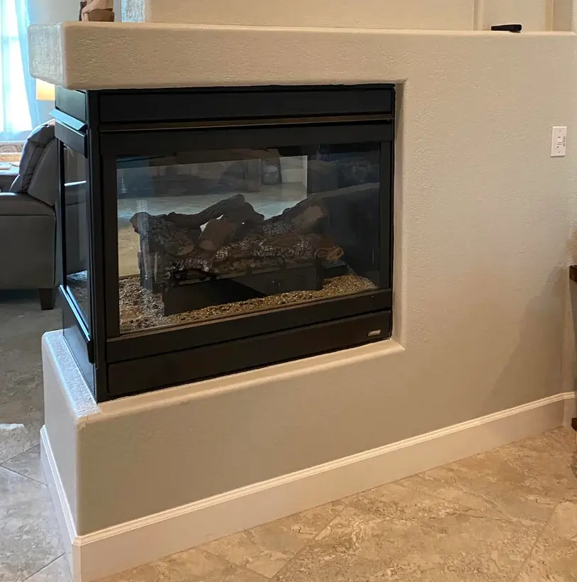 Modern three sided glass gas fireplace in living room corner