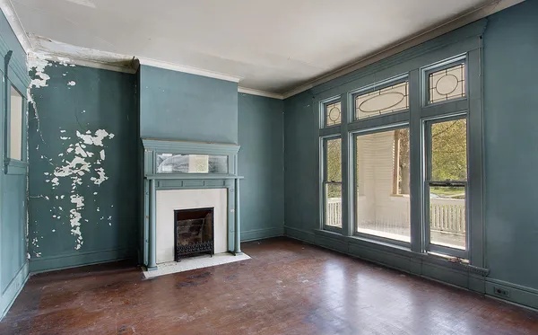 A living room with fireplace in old abandoned home