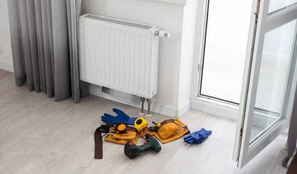 Central heating radiator with handyman tools for reparation